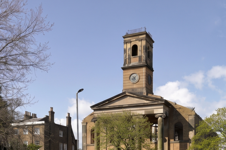 Sheerness Dockyard Church tower amongst trees and buildings on sunny winter day